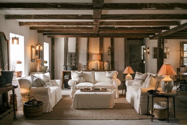 Rustic farmhouse living room featuring comfortable sofas, wooden beams, and warm lighting for a cozy.