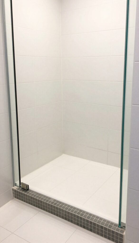 Classic tile shower base with a curb and frameless glass door