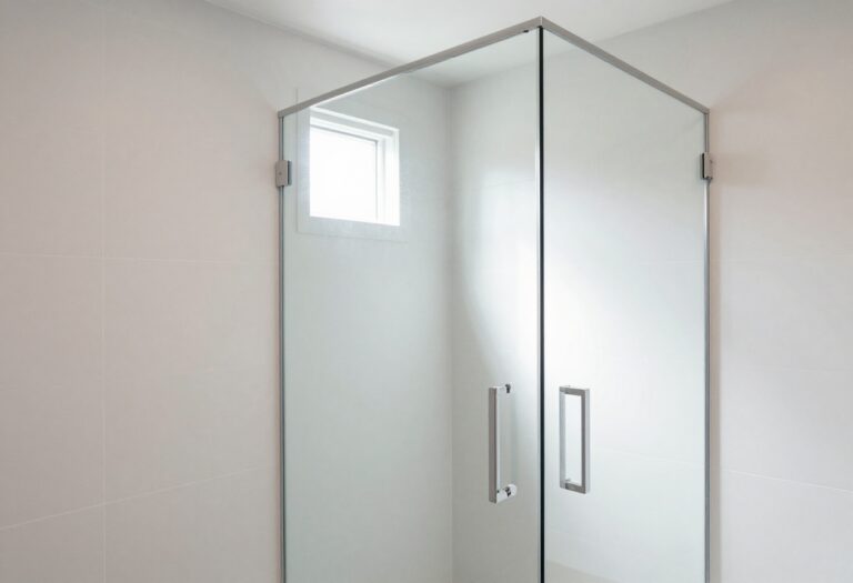 Modern bathroom with a frameless clear glass shower door in bright natural light, highlighting clean design and spacious feel for home decor inspiration.