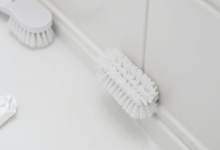 Close-up of clean shower grout with cleaning supplies