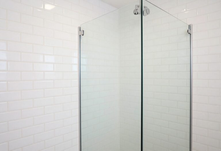Small shower with vertical stacked white subway tiles, glass door, and natural light