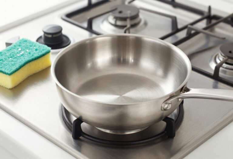 Clean stainless steel pan with baking soda and sponge