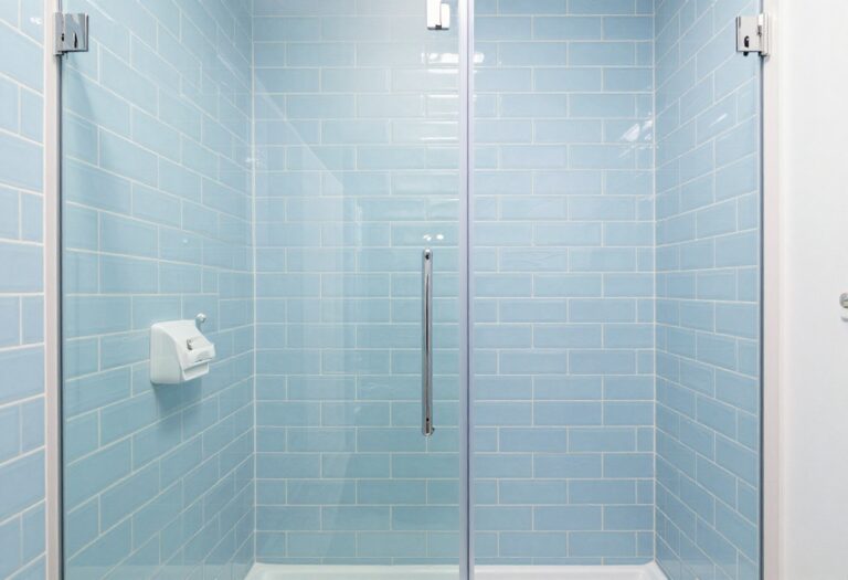 Blue subway tile shower with white fixtures and natural light