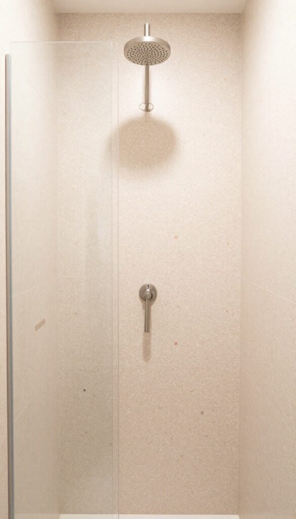 Large-format terrazzo tiles in a modern shower with a brushed nickel rain showerhead, showcasing a playful yet elegant design.